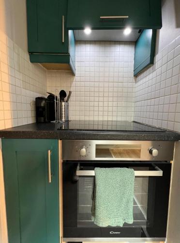 a kitchen with green cabinets and an oven with a towel at Temple Bar Apart in Dublin