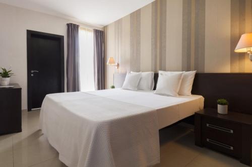 a large white bed in a hotel room at Valletta view Apartments by ST Hotels in Il- Gżira