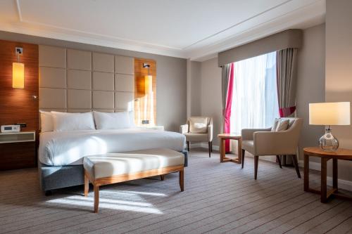 a hotel room with a bed and a chair at Hilton Cambridge City Centre in Cambridge