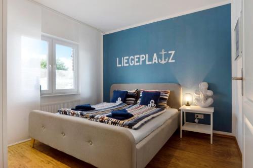 a bedroom with a bed with a blue wall at Ferienhaus Nordlicht in Geeste