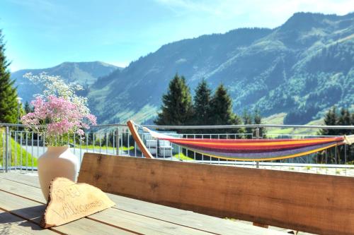 a hammock on a deck with a view of a mountain at Hölderle Damüls in Damuls