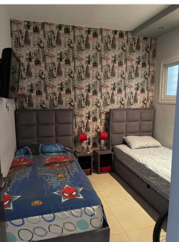 マルティルにあるRyad martilのベッドルーム1室(ベッド1台、スパイダーマンの壁紙を使用したカーテン付)
