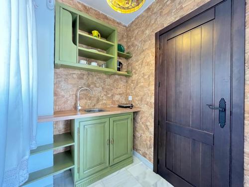 uma cozinha com armários verdes e uma porta em Cortijo Domínguez - Rural Experience em Lucena