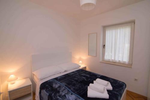 a bedroom with a bed with two towels on it at Apartment in Veli Losinj 34691 in Veli Lošinj
