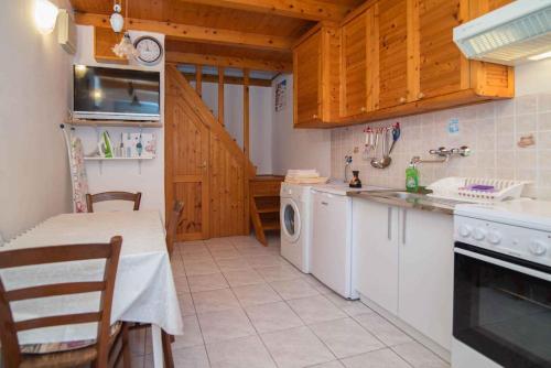 a kitchen with a table and a sink and a dishwasher at Apartment in Veli Losinj 26456 in Veli Lošinj