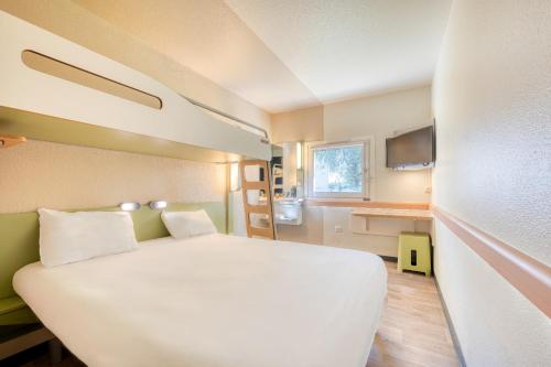 - une chambre avec un grand lit blanc dans l'établissement ibis budget Versailles - Trappes, à Trappes