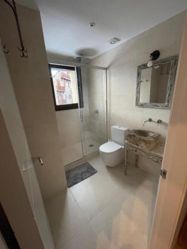 La salle de bains blanche est pourvue d'une douche et de toilettes. dans l'établissement CASA CON ENCANTO ESTERRI, à Esterri d'Àneu