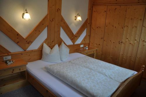 sypialnia z białym łóżkiem i drewnianymi ścianami w obiekcie Ferienhaus Brigitte w Langenfeld