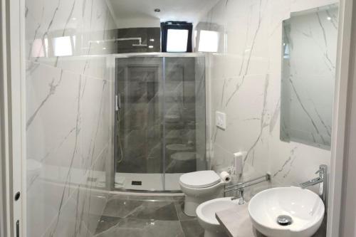 bagno bianco con servizi igienici e lavandino di La Torre CASA SUL MARE a Manfredonia