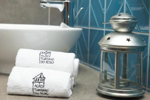 a bathroom with towels and a lantern on a counter at Agro-Turismo do ROXO in Santa Vitória