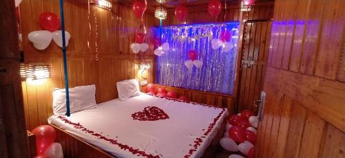 a room with a bed with red and white balloons at Altaf's motel in Matheran
