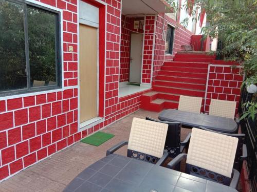 a patio with a table and chairs and some stairs at Altaf's motel in Matheran