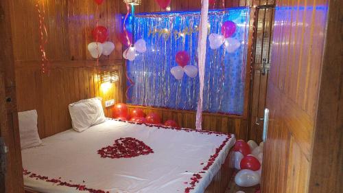 a room with a bed with red and white balloons at Altaf's motel in Matheran