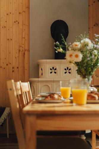 a wooden table with plates of food and orange juice at Miło las widzieć in Ciwoniuki