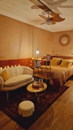 un salon avec un lit et un canapé dans l'établissement Studio 2 pers aux inspirations 60s, à Chalon-sur-Saône