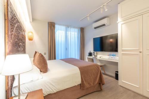 Habitación de hotel con cama y escritorio en Serennia Fira Gran Via Exclusive Rooms, en Hospitalet de Llobregat