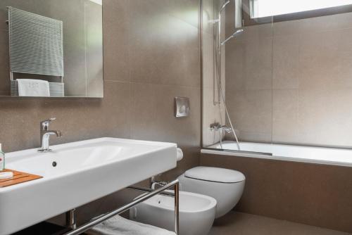 un bagno con lavandino, WC e vasca di Eden Hotel a Bormio