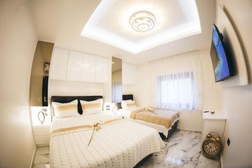 - une chambre avec 2 lits et une grande fenêtre dans l'établissement Luxury Apartment & Rooms, à Ljubuški