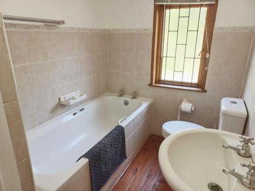 ein Badezimmer mit einer Badewanne, einem Waschbecken und einem WC in der Unterkunft The beach cabin with pool in Port Alfred