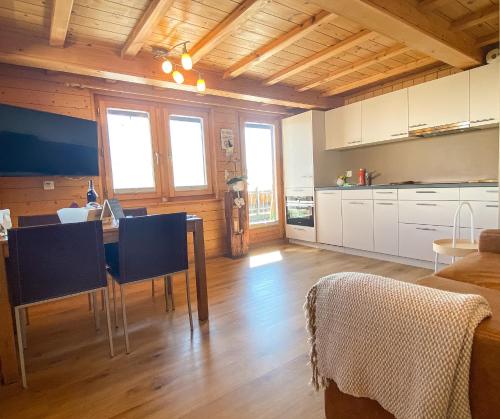 eine Küche und ein Wohnzimmer mit einem Tisch und Stühlen in der Unterkunft Bergquelle 1.OG Ost in Bettmeralp