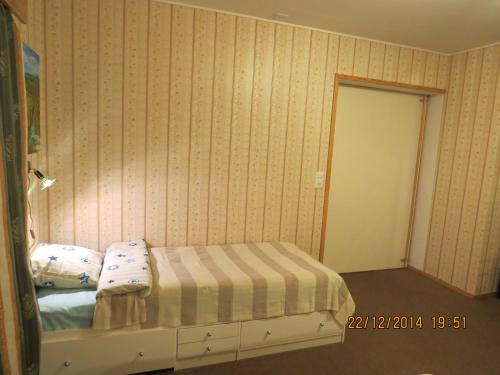 a bedroom with a bed with a striped bedspread at Half a house w/your own door, 60m2 in Tornio
