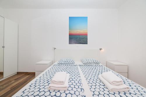 a white bedroom with a large bed with two white chairs at Villa Miri in Privlaka