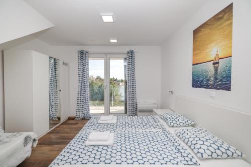 a white room with a bed and a large window at Villa Miri in Privlaka