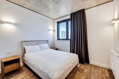 a bedroom with a white bed and a window at Repton Gardens at Wembley Park in London