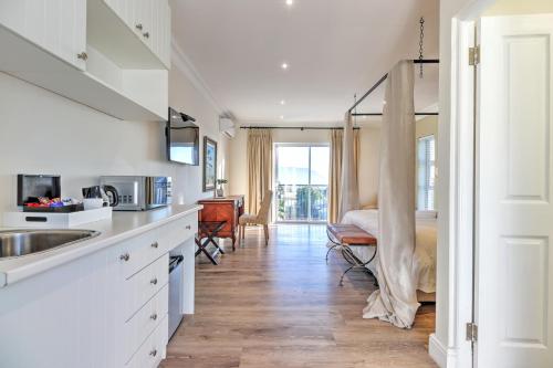 a kitchen with a sink and a bed in a room at Thyme Wellness Spa and Guesthouse in Cape Town