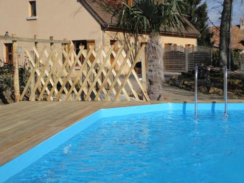 a swimming pool in front of a wooden fence at Gîte avec vue imprenable in Fougerolles