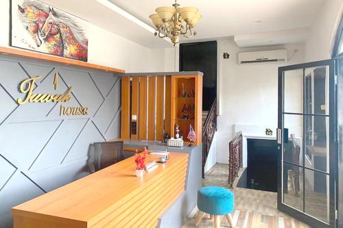 un restaurante con una mesa de madera en una habitación en Urbanview Hotel Syariah House of Tuwuh, en Tanjungkarang