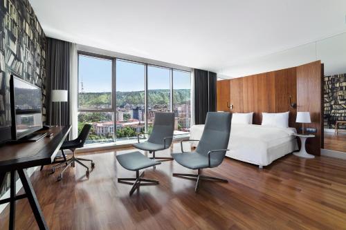Pokój hotelowy z łóżkiem, biurkiem i krzesłami w obiekcie Holiday Inn - Tbilisi, an IHG Hotel w mieście Tbilisi City