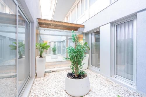 a balcony with two potted plants in a building at Serennia Fira Gran Via Exclusive Rooms in Hospitalet de Llobregat