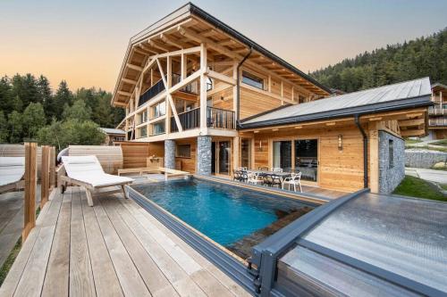 ein Blockhaus mit einem Pool auf einer Terrasse in der Unterkunft Chalet Béla Vya 5 étoiles luxe Ski & Spa in Bourg-Saint-Maurice