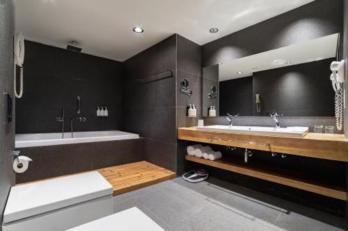 a bathroom with two sinks and a bath tub at Holiday Inn - Tbilisi, an IHG Hotel in Tbilisi City