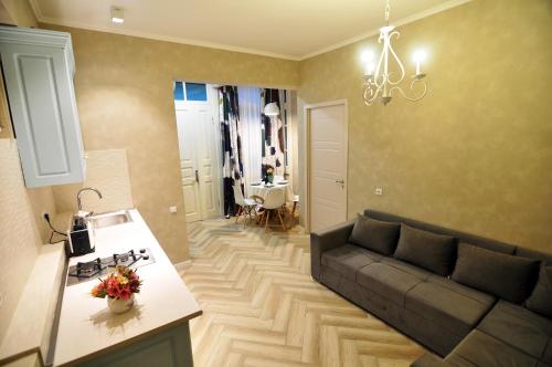 uma sala de estar com um sofá e uma cozinha em Elis Sweet Home em Tbilisi