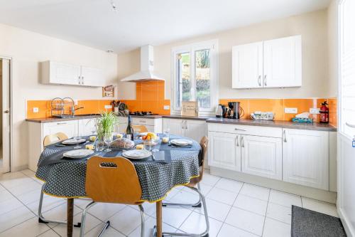 une cuisine avec une table et des chaises dans une pièce dans l'établissement Logement 3ch 8 personnes, à Saint-Hilaire-de-Voust