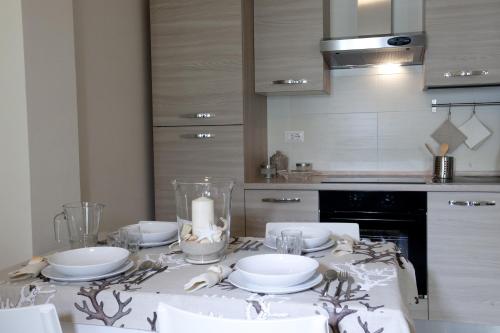 a kitchen with a table with white dishes on it at Casavacanze Castelli di Sabbia in Porto SantʼElpidio