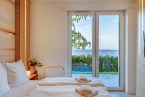 een slaapkamer met een bed en een groot raam bij MF Club 218 Garden Apartments in Siófok
