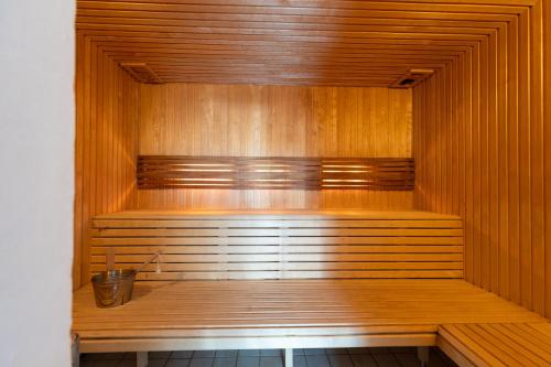 a wooden sauna with a bucket in the middle at Langeland luksuslejlighed med pool og spa in Rudkøbing