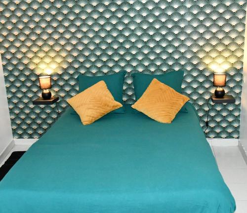 - une chambre avec un lit bleu et 2 oreillers jaunes dans l'établissement Appartement 32 m2 intra muros - WIFI - Netflix - Bureau, à Avignon