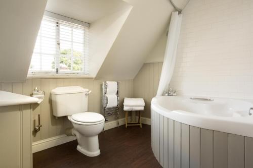 a white bathroom with a toilet and a sink at The George Hotel & Brasserie, Cranbrook in Cranbrook