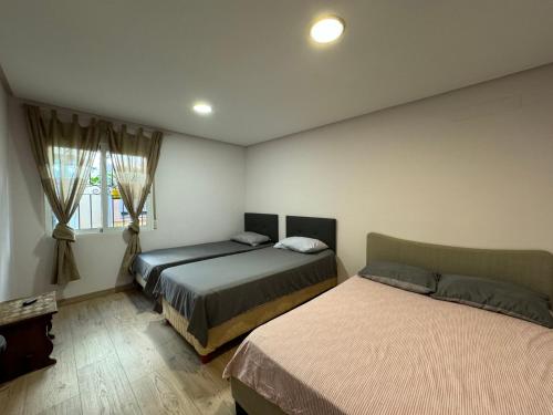 サン・ハビエルにあるDos Mares Comfort & Calidad- Casa entera Planta Bajaのベッドルーム1室(ベッド2台、窓付)
