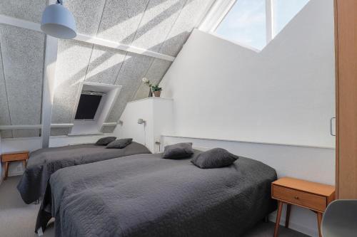 a bedroom with two beds and a window at Langeland luksuslejlighed med pool og spa in Rudkøbing