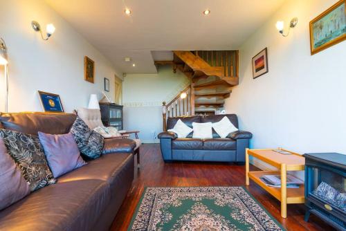 a living room with a leather couch and a table at Midsummer Barn in Darwen