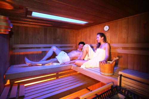 a man and two women sitting in a sauna at Top Tirol Appartement in Längenfeld