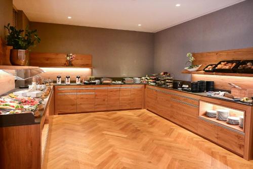a kitchen with wooden floors and a counter with food at Hotel Rittergut Stoermede in Geseke