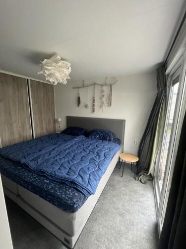 a bedroom with a bed with a blue comforter at NV 1220 - Beach Resort Nieuwvliet Bad in Nieuwvliet