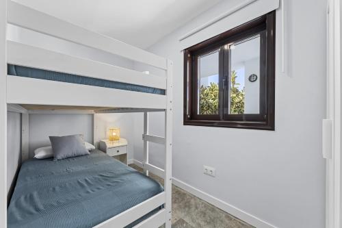 a bedroom with a bunk bed and a window at Casa Aldea in Puerto del Carmen