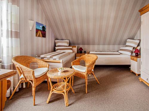 Cette chambre comprend deux lits, une table et des chaises. dans l'établissement Walther, à Soltau